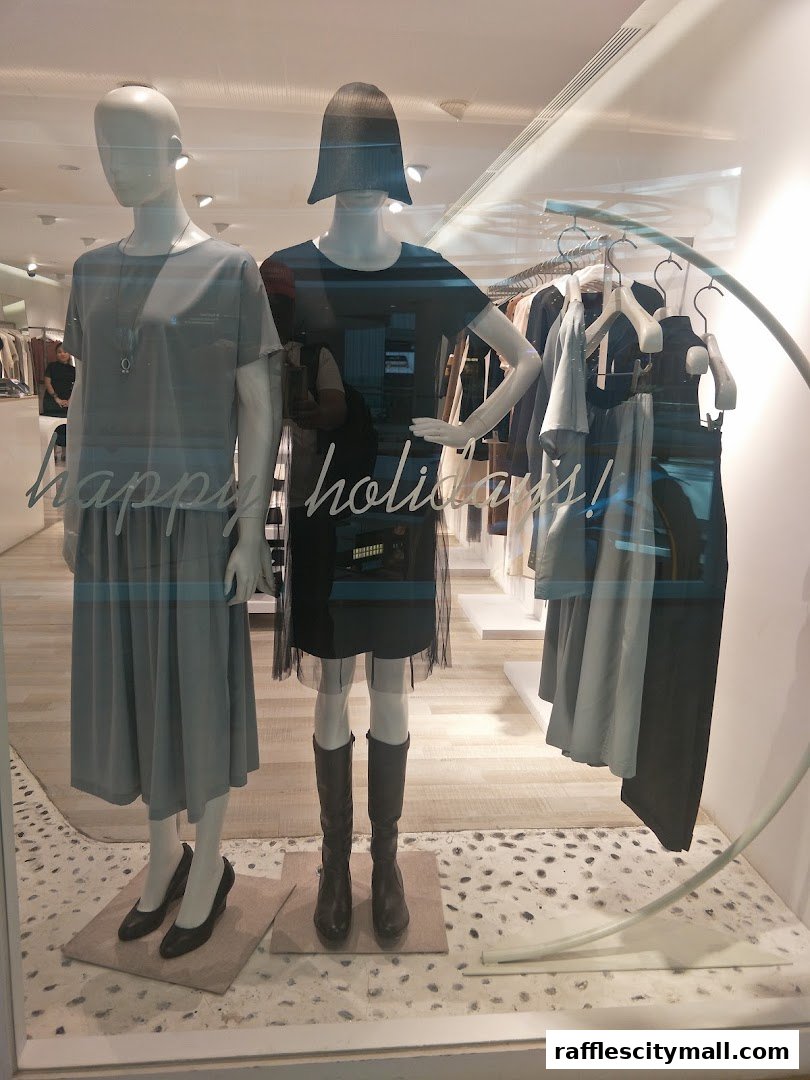 Mannequins in a shop window display featuring stylish dresses and accessories.