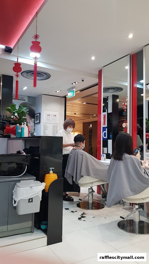 Hairdresser cutting a client's hair in a modern salon with red accents.