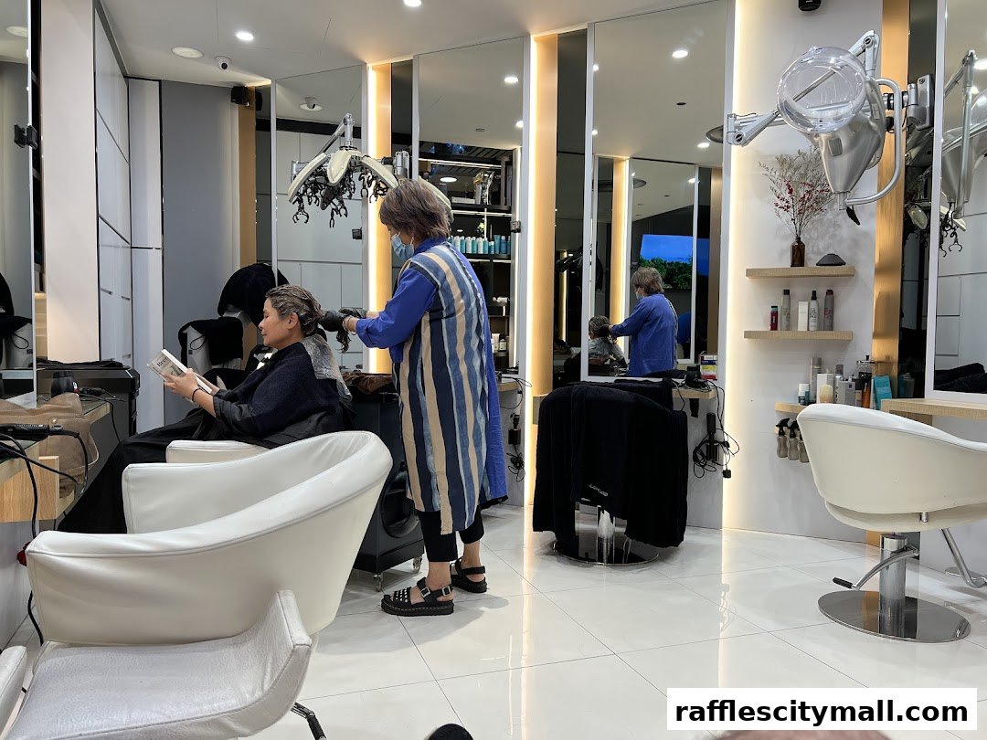 A client reads a book while a stylist applies hair treatment in a modern salon.