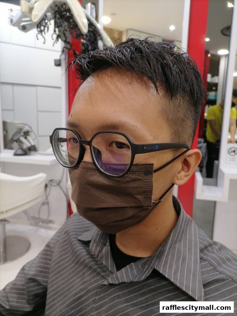 A close-up of a person wearing glasses and a mask in a salon.