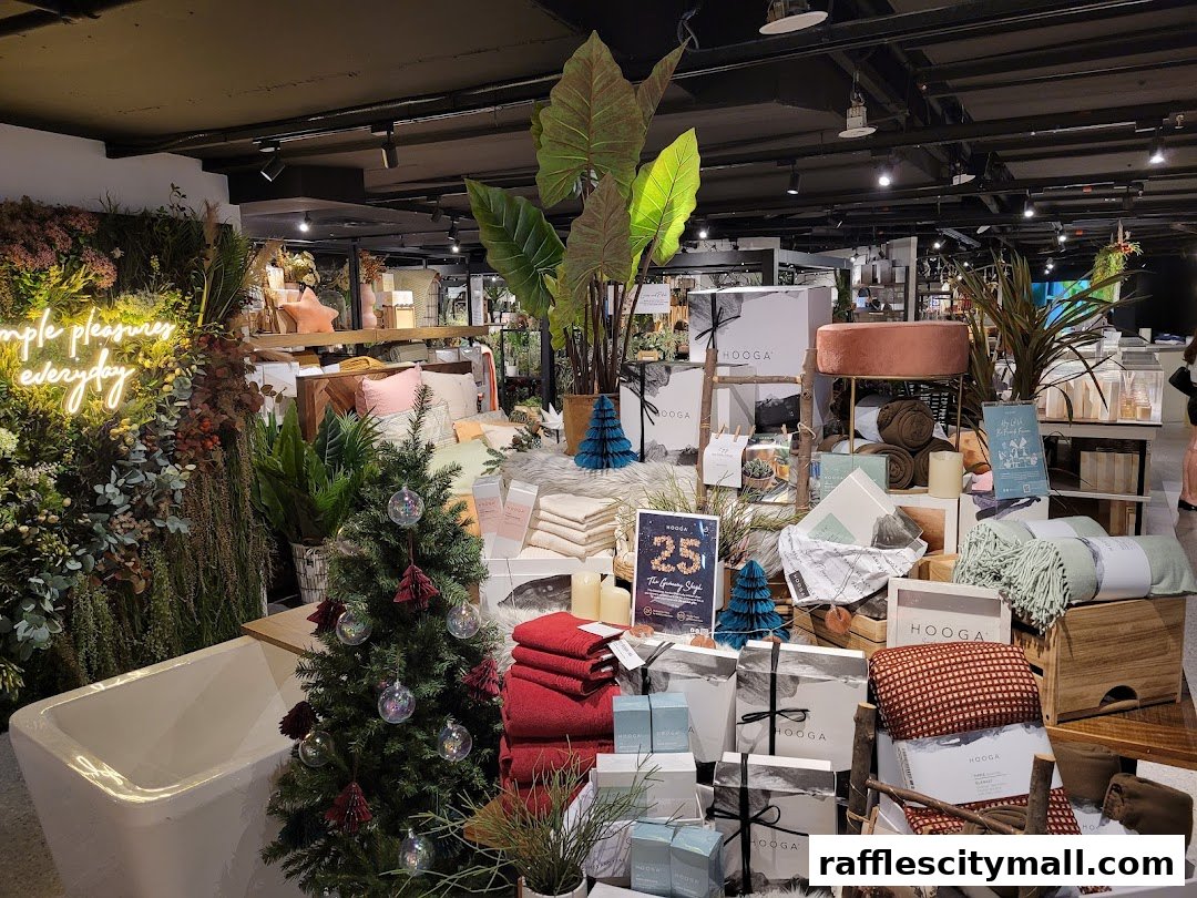 A retail store interior showcasing home decor items, including blankets, pillows, and a Christmas tree.