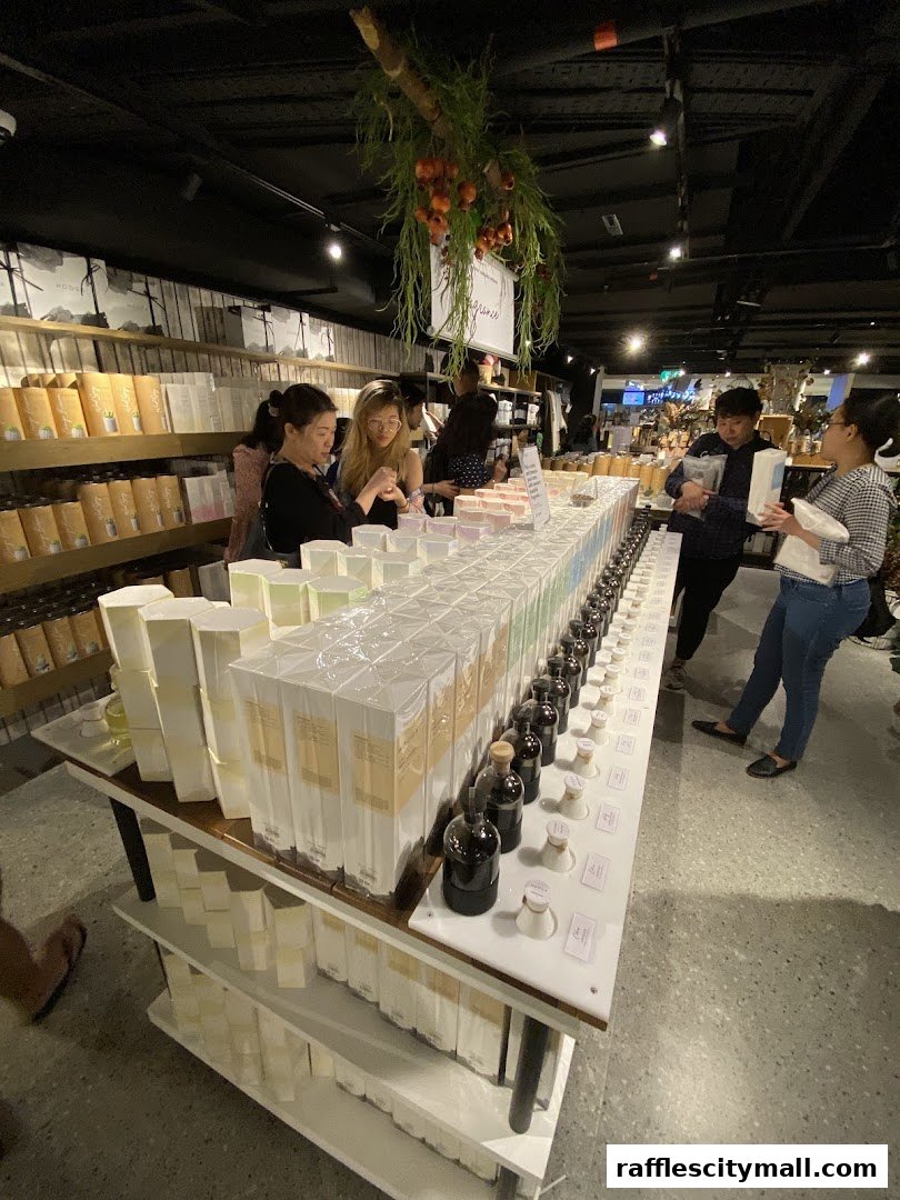Customers browsing a well-stocked retail store with many products displayed on shelves and a central table.
