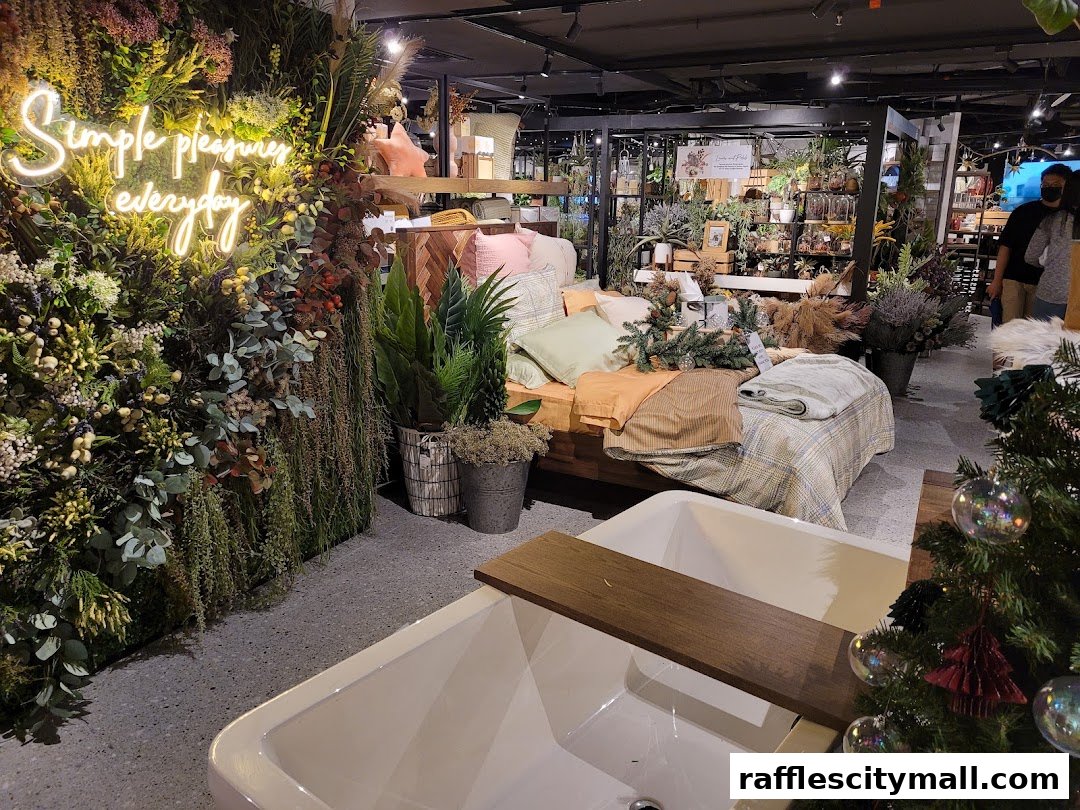 Interior of a home decor store with a bed display, plants, and a bathtub.