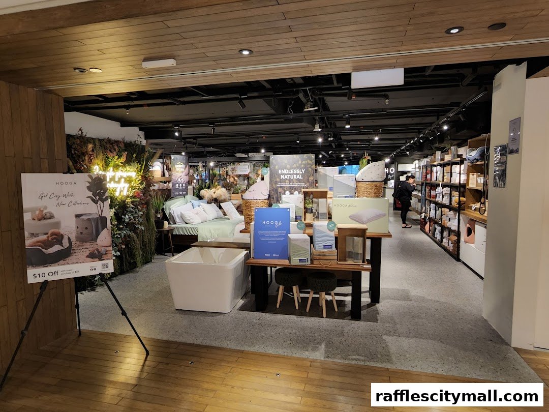 Interior view of HOOGA Raffles City shop showcasing bedding, home decor, and a promotional sign.