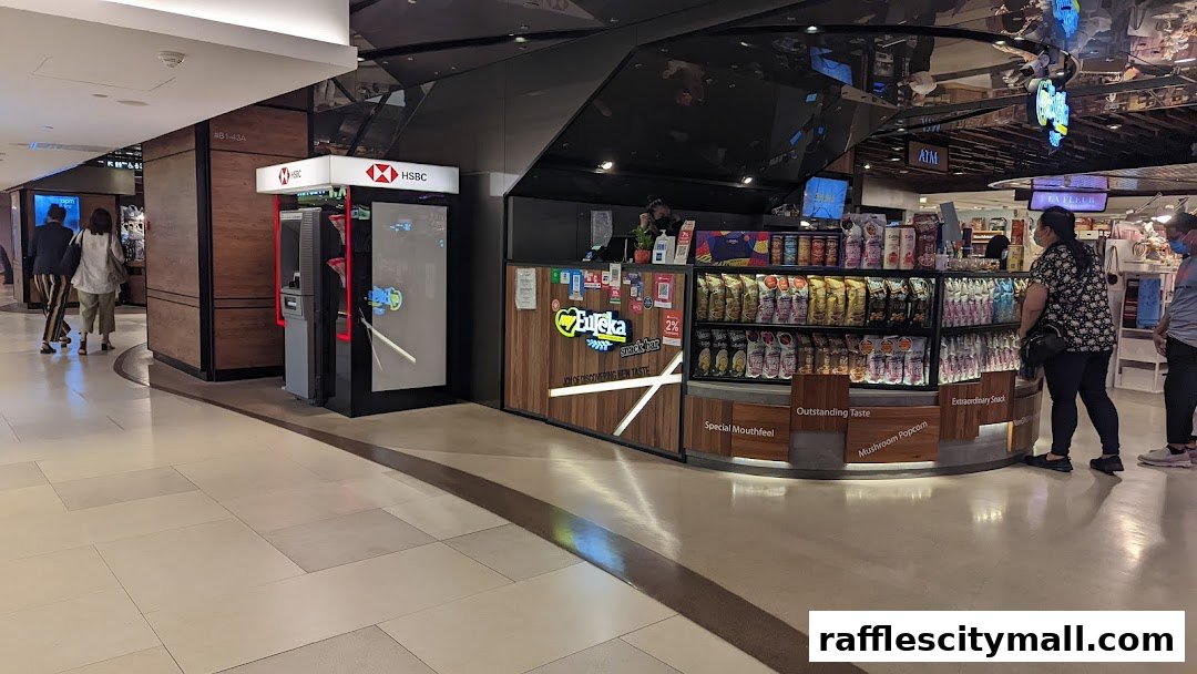 A snack bar and an ATM are visible in a shopping mall, with people walking by.