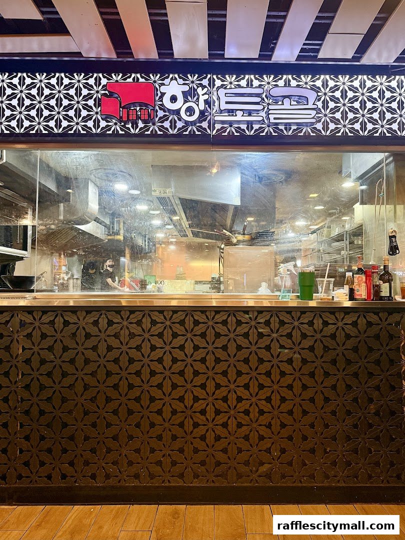 View of a Korean restaurant kitchen through a glass window with the restaurant name above.
