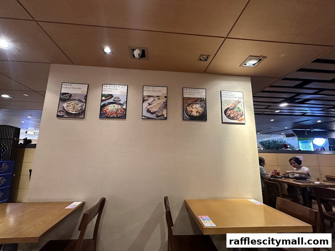 A wall in a Korean restaurant displaying pictures of various dishes and tables.