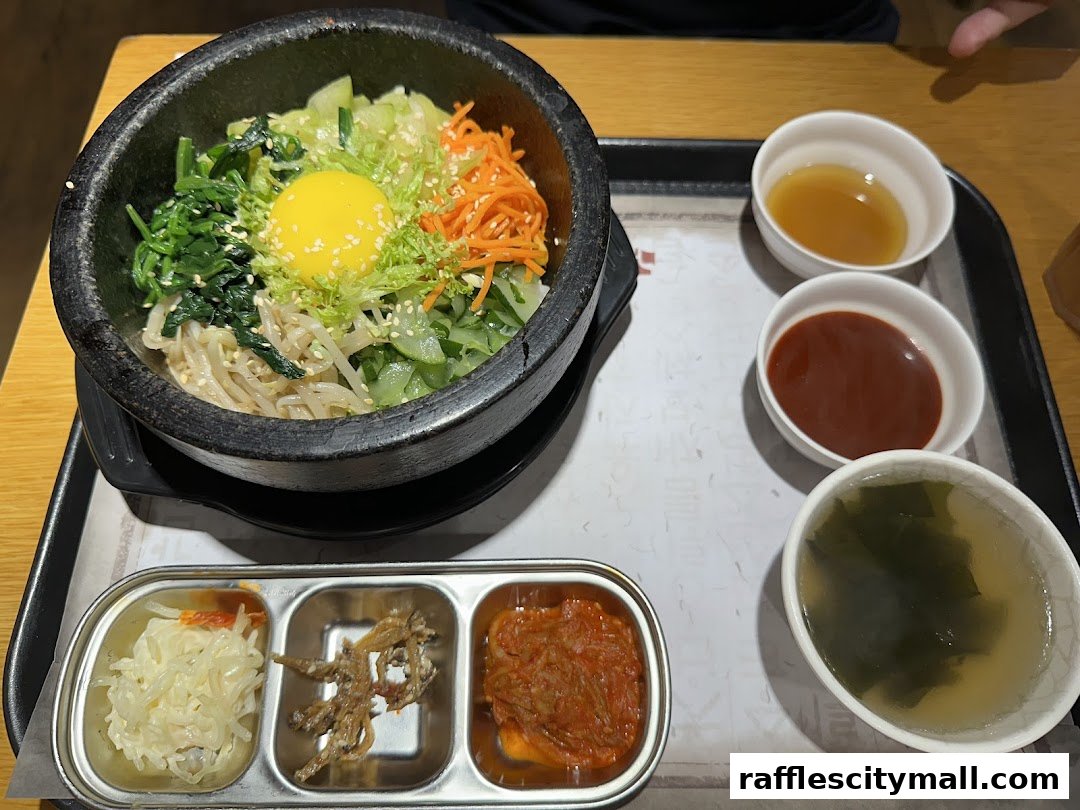 A sizzling hot stone bibimbap served with assorted side dishes and soup.