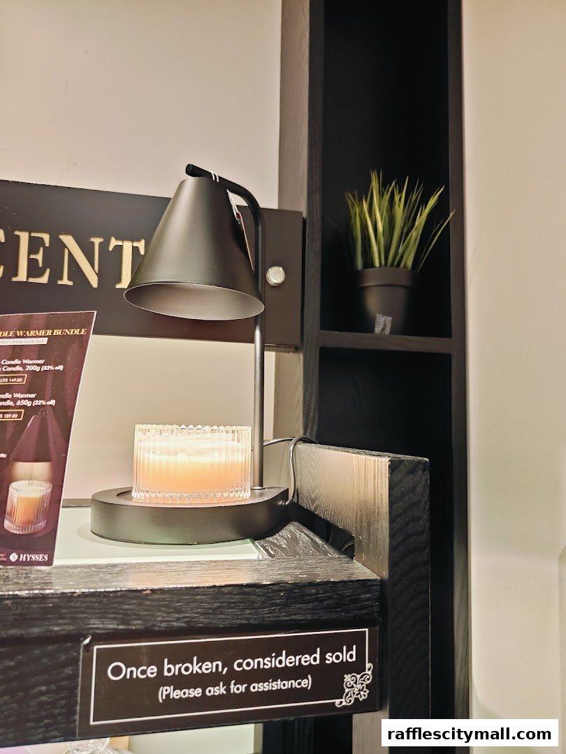 A candle warmer with a lit candle and a product display for HYSSES.