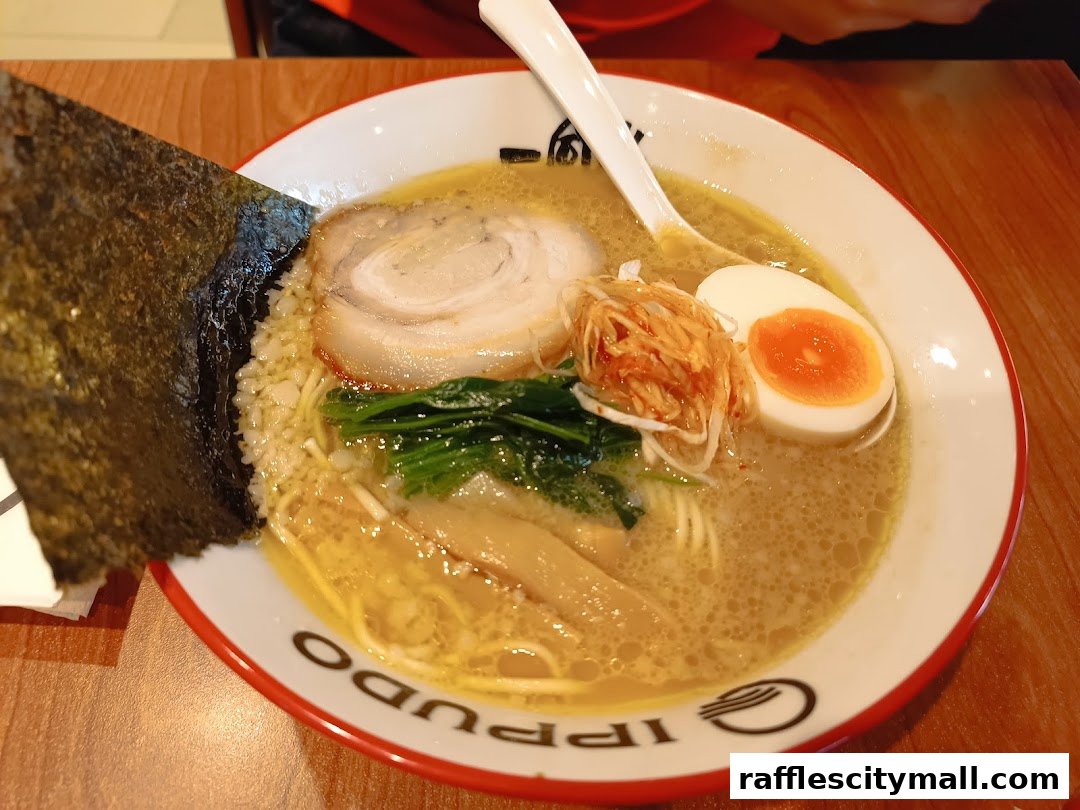A close-up of a delicious bowl of ramen with pork, egg, seaweed, and bamboo shoots.