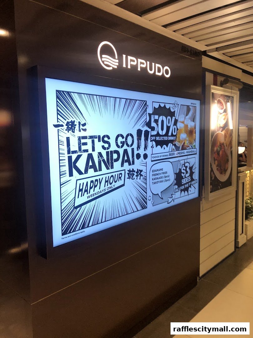 A digital display board outside an IPPUDO restaurant advertising a happy hour with drink and side dish specials.