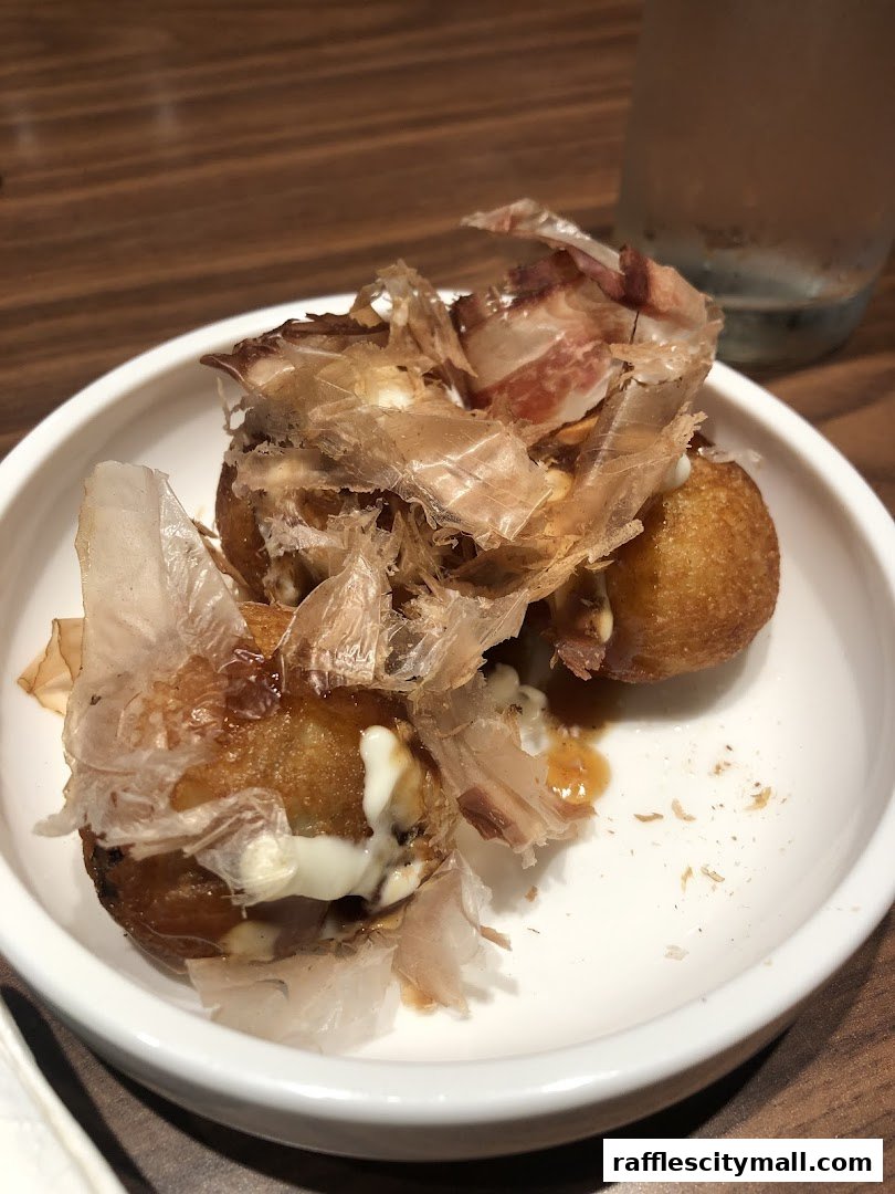 A close-up of takoyaki, Japanese octopus balls, topped with bonito flakes and sauce.