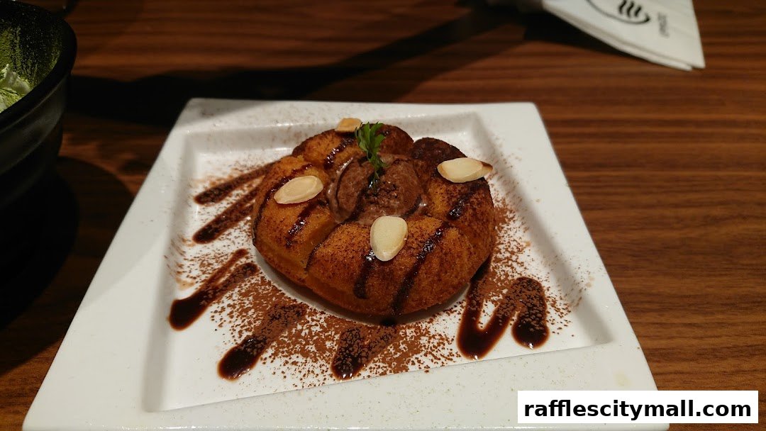 A close-up of a dessert with ice cream, almonds, and chocolate sauce on a white plate.