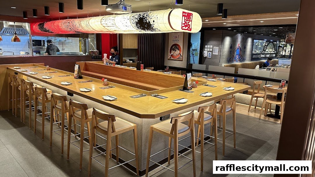 Interior of a modern ramen restaurant with a large U-shaped counter and bar stools.