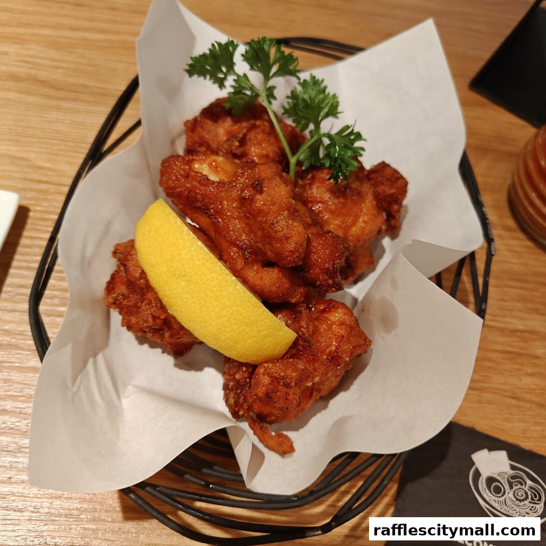 A basket of crispy fried chicken with a lemon slice and parsley garnish.