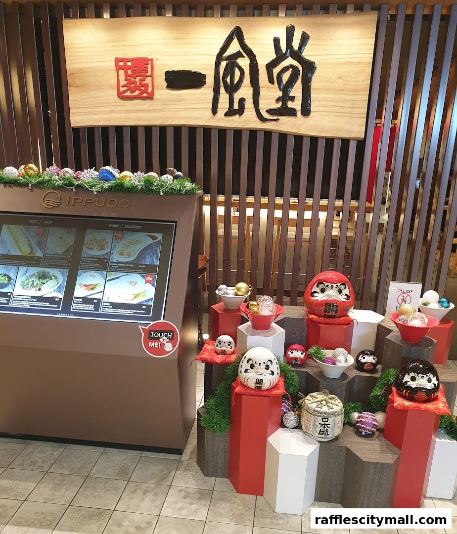 IPPUDO Raffles City shop interior with a digital menu and festive Daruma doll decorations.