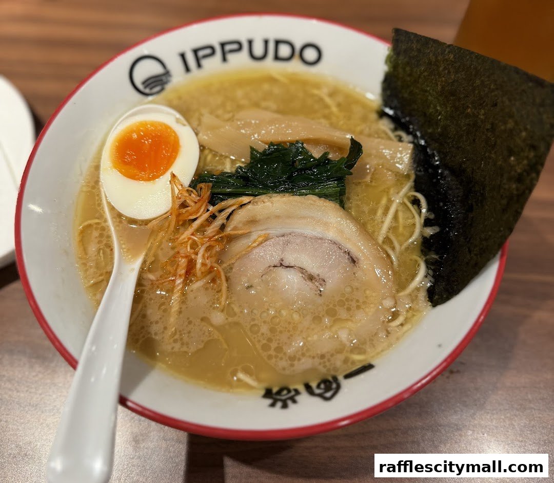 A close-up of a delicious bowl of ramen with a soft-boiled egg, pork, and nori.