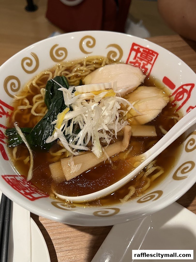 A close-up shot of a delicious bowl of ramen with chicken, bamboo shoots, and greens.