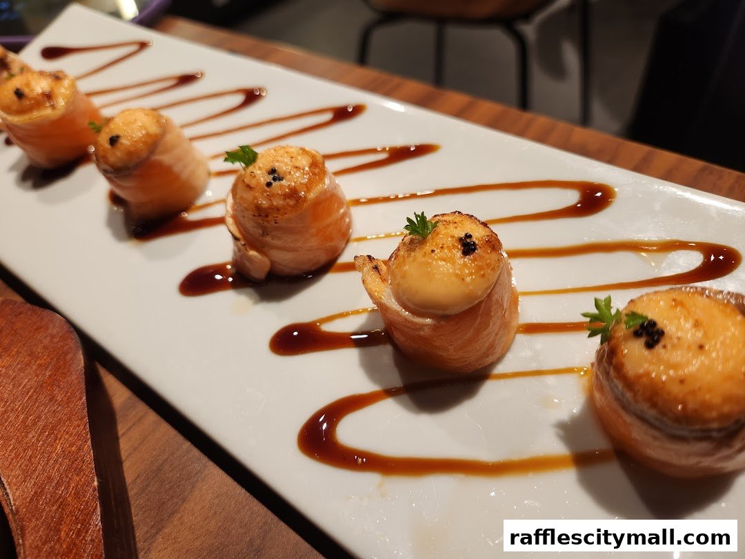 A plate of five salmon rolls with sauce and garnish, presented on a white platter.
