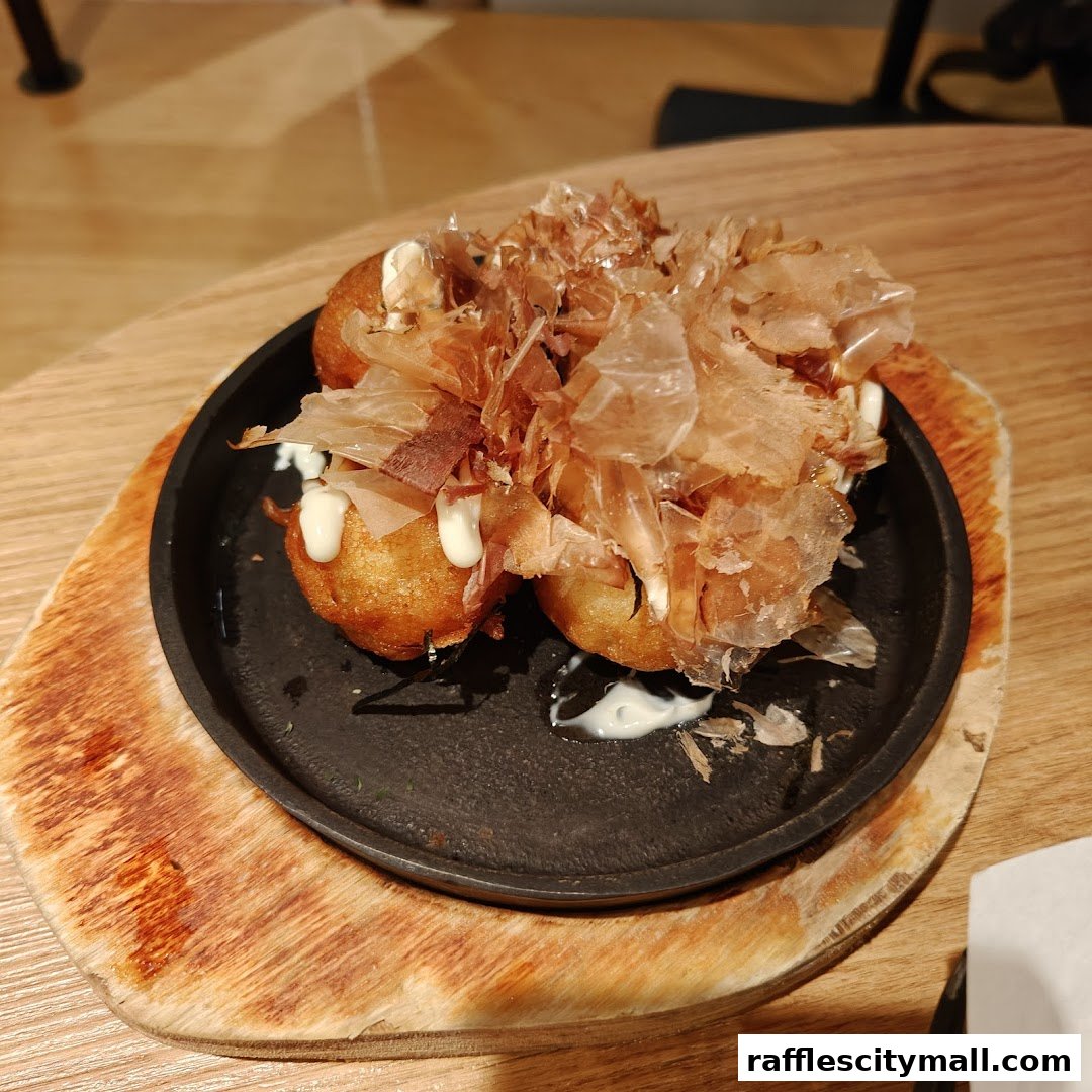 A close-up of takoyaki, Japanese octopus balls, topped with bonito flakes and sauce.