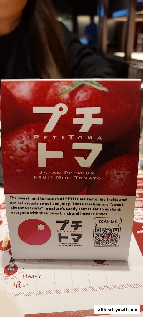 A promotional card for PETITOMA Japan Premium Fruit Mini-Tomatoes.