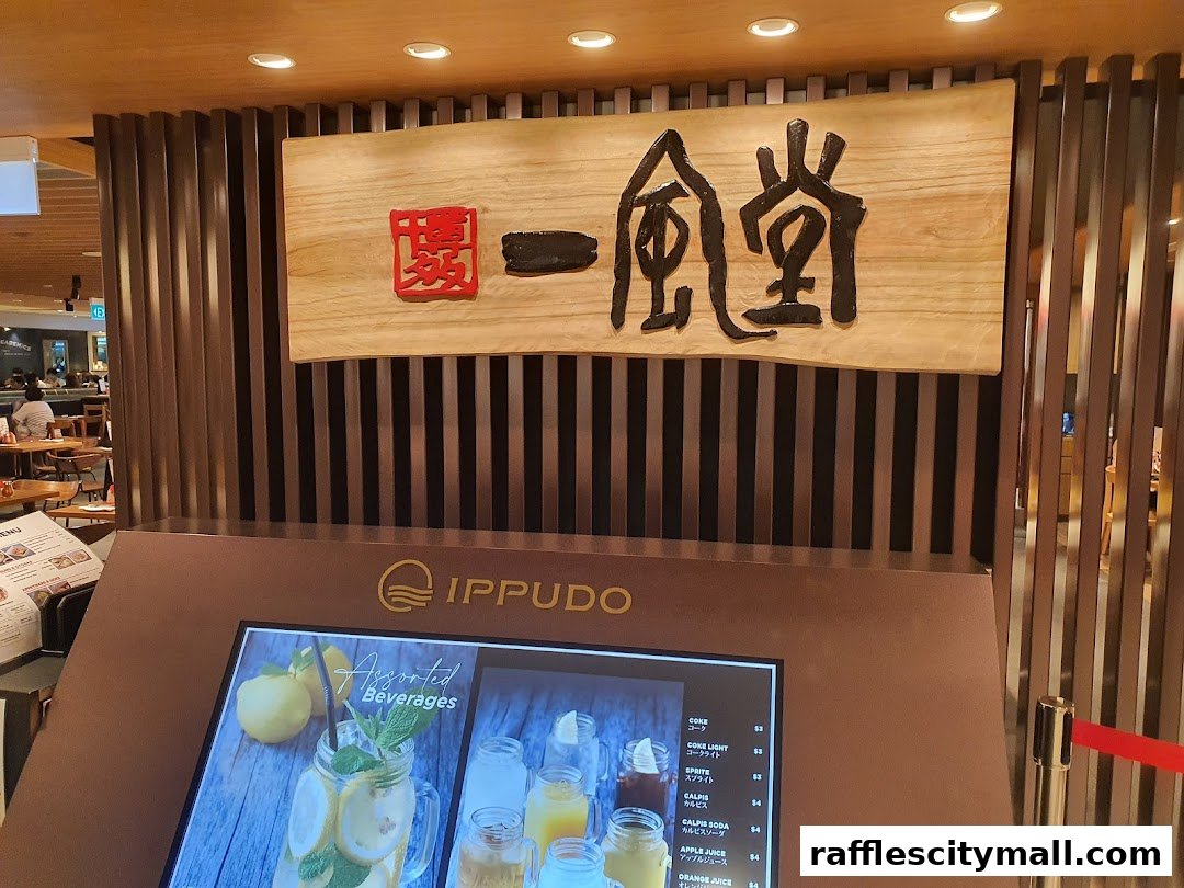 The entrance of IPPUDO Raffles City with its prominent signage and a digital menu display.