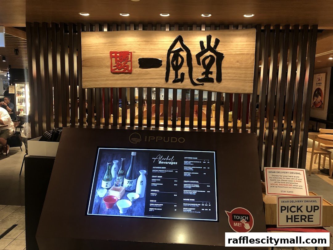The entrance of Ippudo Raffles City with a digital menu displaying alcoholic beverages.