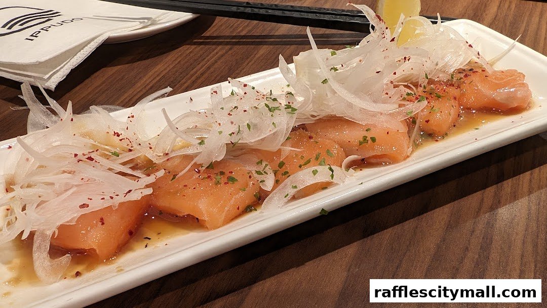 A plate of salmon sashimi with thinly sliced onions and a light dressing.