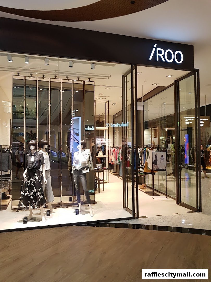 The modern storefront of iROO Raffles City Shopping Centre, featuring mannequins and clothing displays.