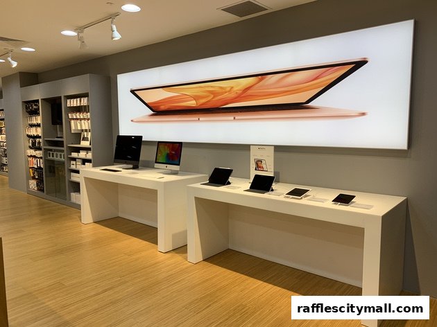Interior of an iStudio shop showcasing Apple products on display tables and shelves.