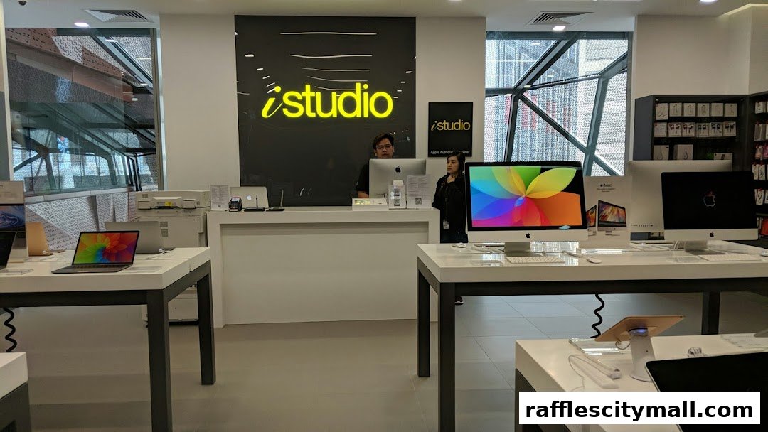 Interior of an iStudio shop showcasing Apple products and staff at the counter.
