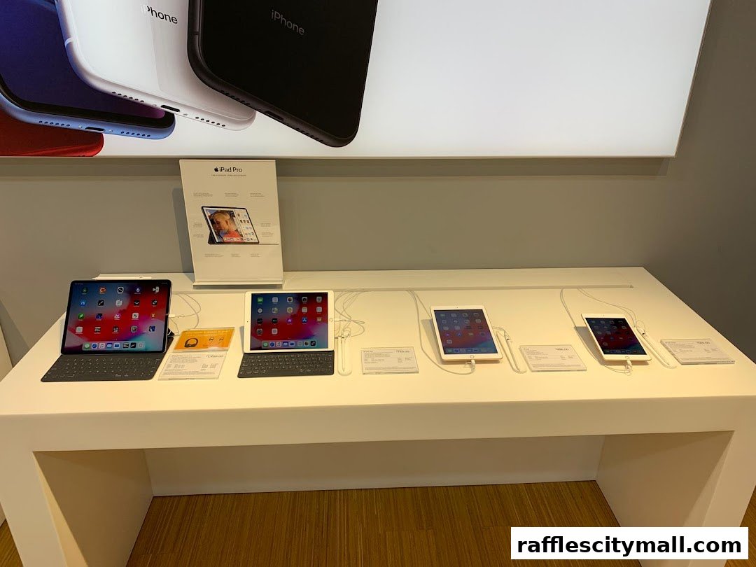 Display of various iPad Pro models with keyboards and accessories on a white counter.