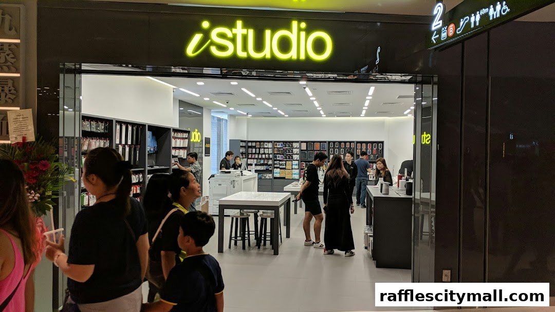 The entrance of an iStudio electronics store with customers browsing inside.