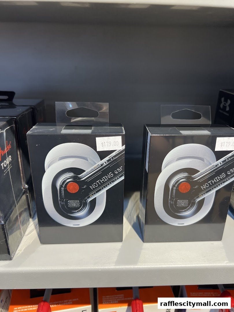 Two boxes of white wireless earbuds with red accents are displayed on a shelf.