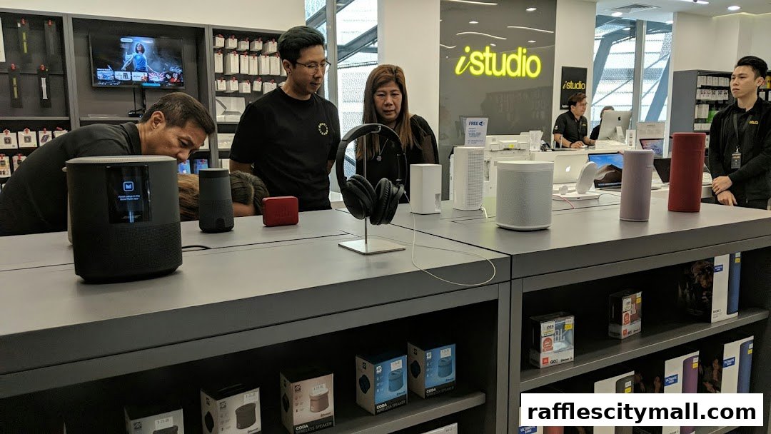 Customers explore audio devices at iStudio Raffles City, with staff present.
