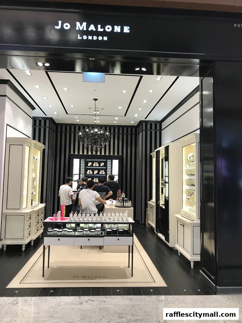 The entrance of a Jo Malone London store with displays of perfumes and staff assisting customers.