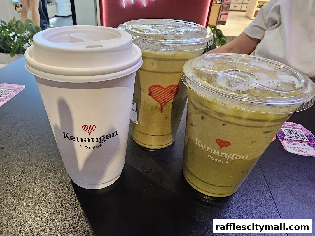Three iced coffee drinks from Kenangan Coffee, two with a green hue and one in a white cup.