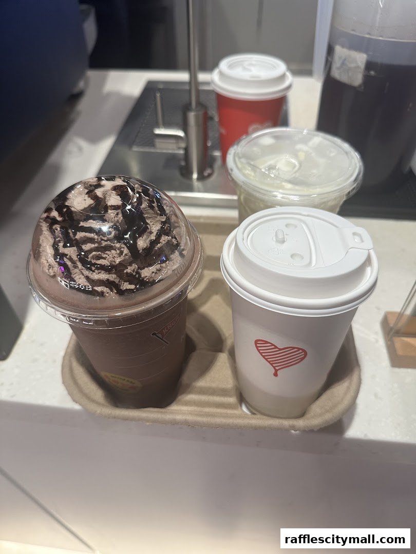 A close-up of various coffee drinks served in cups and a plastic container.