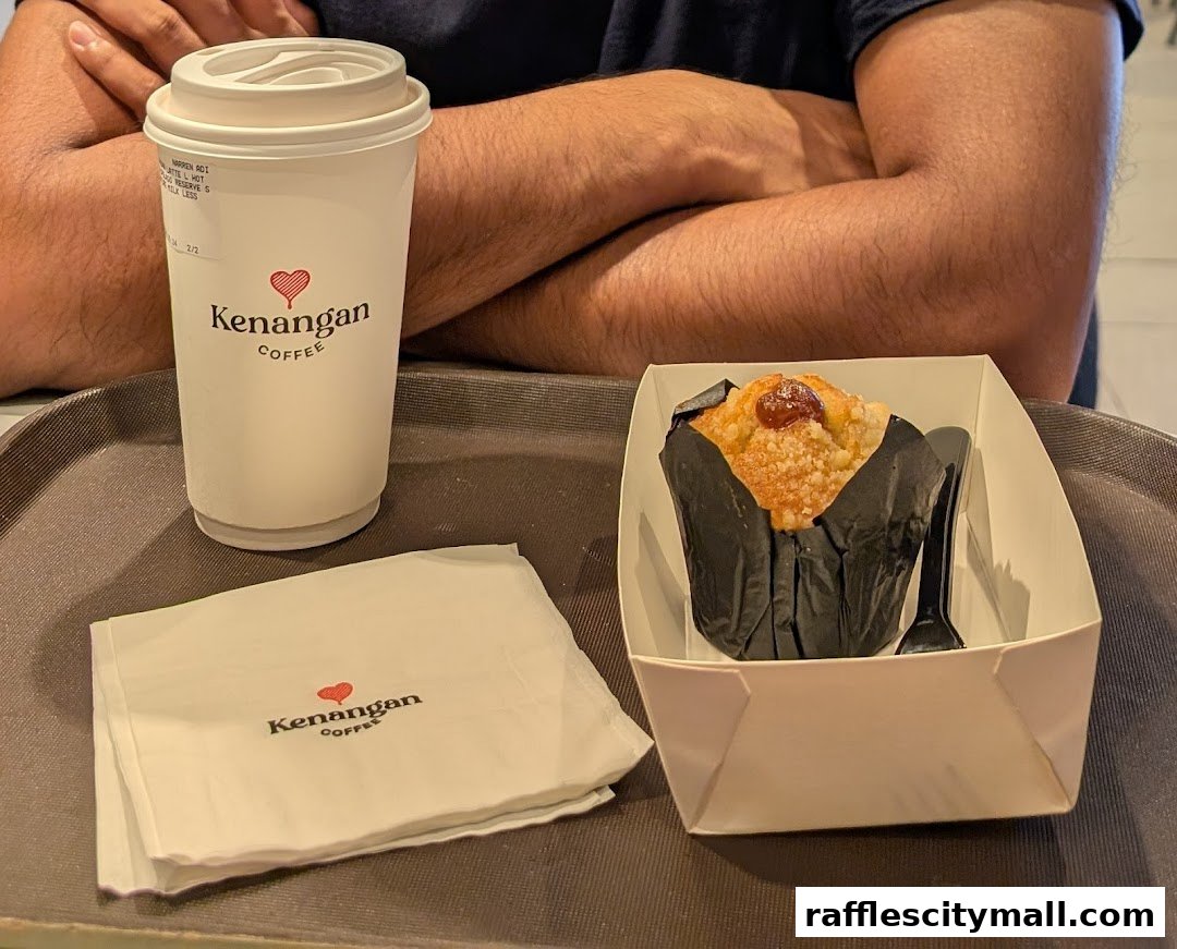 A coffee cup and a muffin on a tray at Kenangan Coffee.