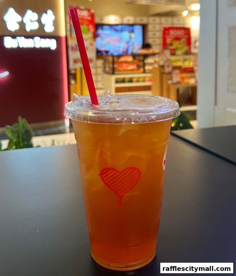A close-up of a refreshing iced tea with a red heart logo on the cup.