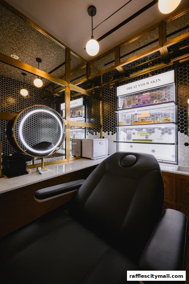 A luxurious treatment room with a reclining chair, illuminated mirror, and skincare products on display.