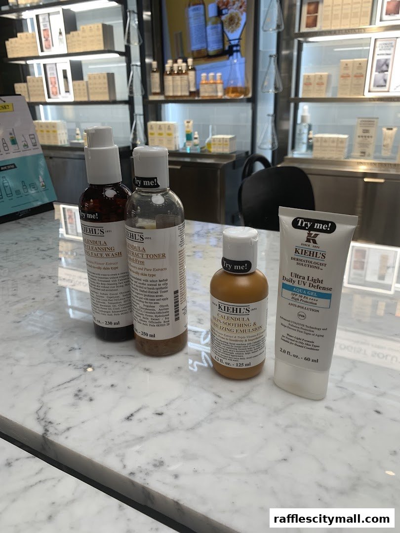 Kiehl's skincare products displayed on a marble counter with shelves of products in the background.
