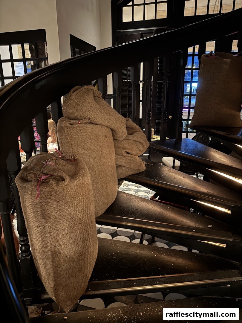 Burlap sacks are displayed on a dark spiral staircase with patterned flooring.