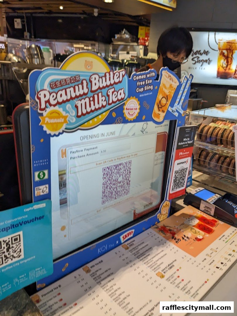 A counter display at KOI Thé Express featuring a new Peanut Butter Milk Tea promotion.