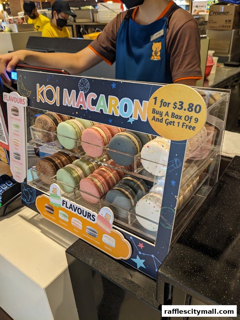 A display case filled with colorful KOI macarons and a promotional offer.
