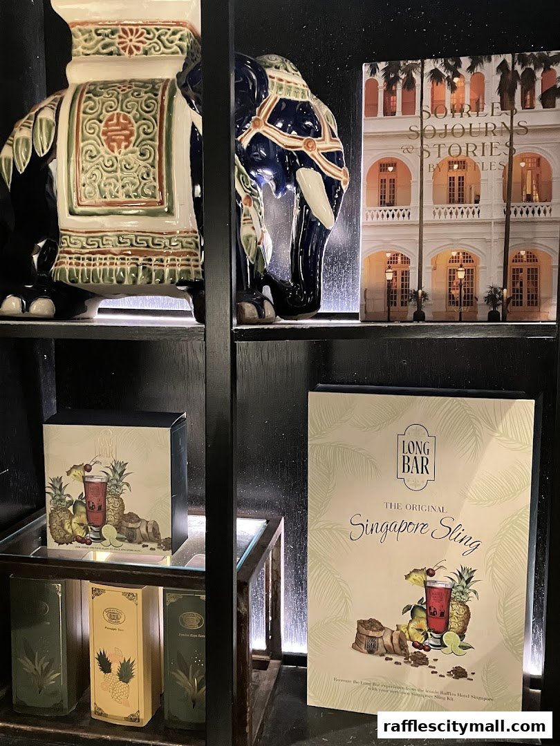 A shelf displays decorative elephants, tea boxes, and a Singapore Sling kit.