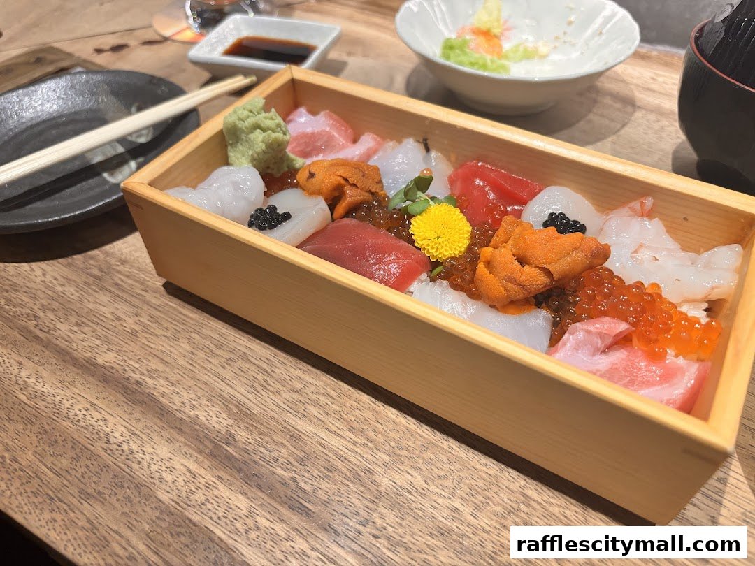 A beautifully presented chirashi sushi bowl with assorted fresh seafood and garnishes.