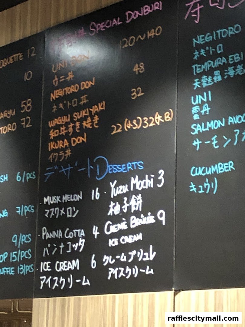 A chalk menu board at Koji Sushi Bar with various Japanese dishes and desserts listed.