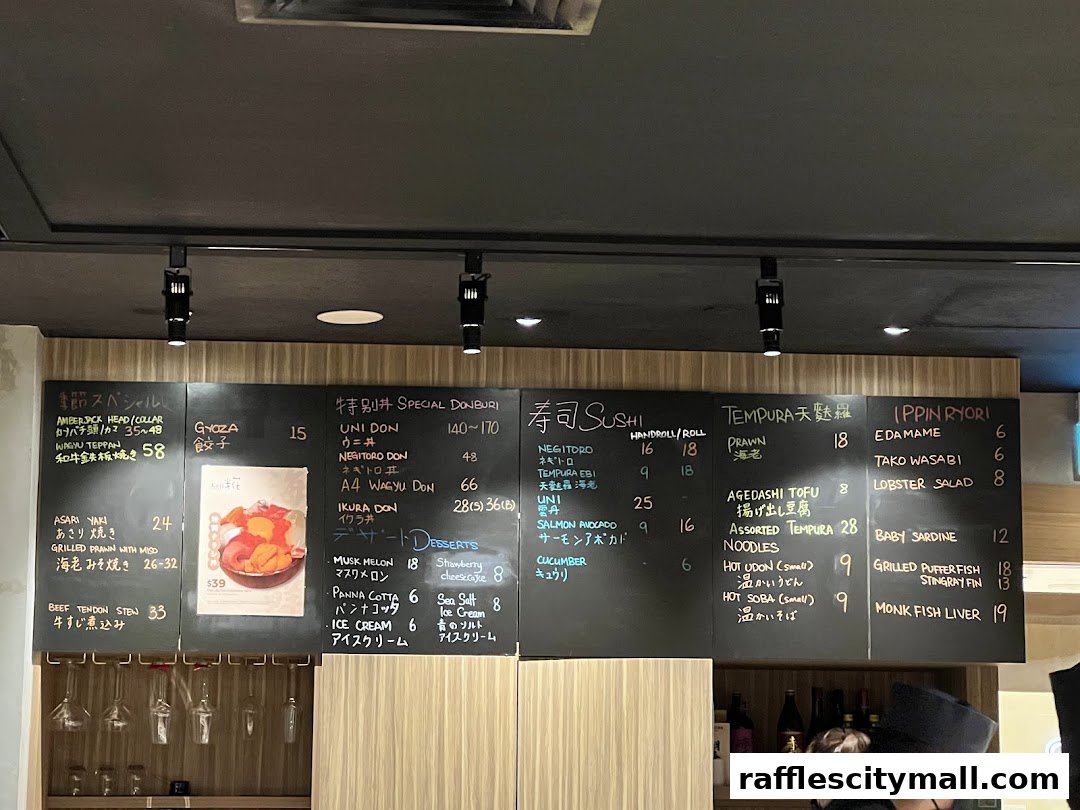 A blackboard menu at Koji Sushi Bar displays various Japanese dishes, including sushi, donburi, tempura, and desserts.