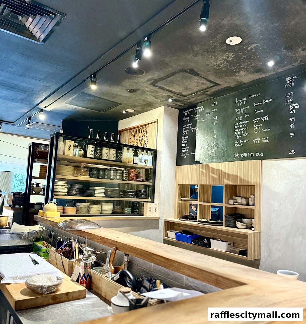 Interior view of a sushi bar with a menu board and shelves stocked with bottles and dishes.